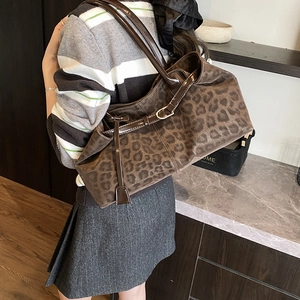 Vintage leopard print tote bag with brown leather straps shown on model shoulder