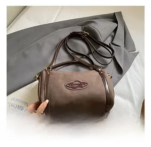 Detail view of the dark brown Boston bag showing frosted texture and gold hardware