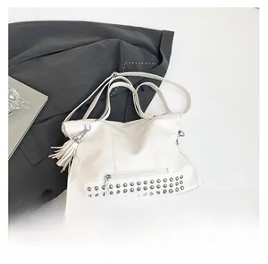 Detailansicht der Ledertasche mit Metallnieten und dekorativem Quastenanhänger