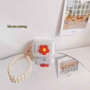 Detail of transparent AirPods case featuring a red flower and pearl beaded handle