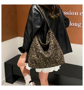 Detail view of oversized leopard print suede hobo bag worn on shoulder for commute