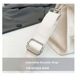 Detail eines verstellbaren weißen Schultergurts aus Leder mit silberner Metallschnalle