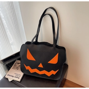 Detail of Halloween pumpkin tote bag in matte black leather with orange Jack-o'-lantern face
