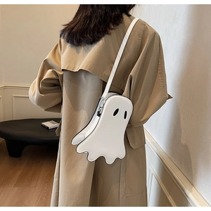 Ghost shaped white leather crossbody bag worn over a stylish beige trench coat