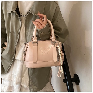 Detail of pink soft leather handbag with embossed letters and bicolor knot charm