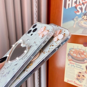 Dettagli della cover iPhone con foglia d'oro, farfalla 3D rosa e specchio a cuore con strass