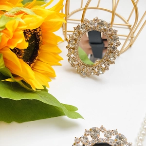 Macro detail of luxury rhinestone folding phone stand with elegant sunflower background