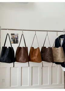 Fünf verschiedene Taschen aus mattem Wildleder in Unifarben und Leopardenprint am Gestell