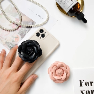 Detail of camellia flower phone grip made of premium leather texture in pink and black