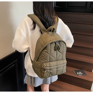 Detail of olive green quilted backpack with water-resistant nylon and diamond patterns