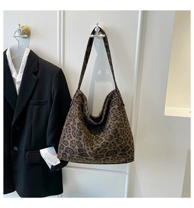 Detail of leopard print tote bag hanging with stylish blazer outfit in modern setting