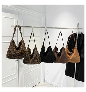 Detailed display of five large leopard print and solid color suede tote bags on a metal hanger