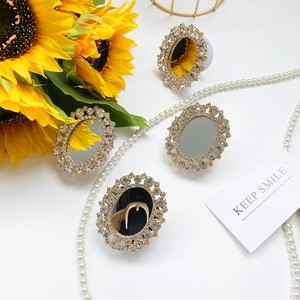 Close-up of elegant rhinestone-embedded folding mirror phone stand with golden finish