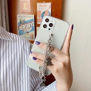 Detail view of transparent iPhone case with silver bear charms and metallic chain strap