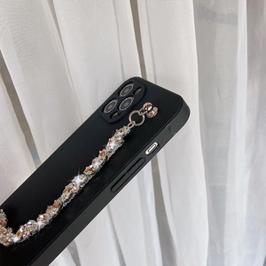 Close-up of black matte phone case featuring a decorative diamond rhinestone chain strap
