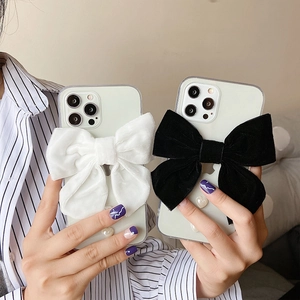 Elegant iPhone case with velvet bow and 3D pearl heart shown held by hand