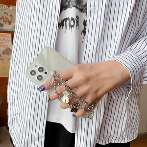 Close-up of transparent phone case with stylish silver metal bear charm bracelet