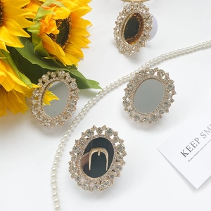 Close-up of elegant rhinestone-encrusted mirror phone grips on white surface