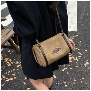Retro khaki suede Boston bag with leather trim worn with a black blazer on street