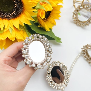 Detail of oval rhinestone-encrusted mirror holder with crystal accents and pearls