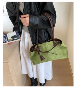 Grass green suede tote bag with dark brown straps worn by a model in a casual outfit