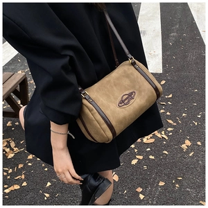 Brown frosted Boston bag shown on a model in an autumn street setting with high texture