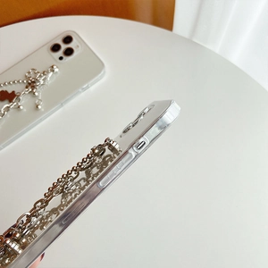 Macro view of transparent phone case featuring a silver metal chain and bear pendant