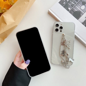 Close-up of clear phone case with decorative silver bear chain and bead charms