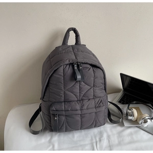 Dettaglio dello zaino trapuntato grigio scuro con tasche multiple e nylon imbottito
