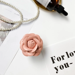 Macro detail of 3D layered pink leather camellia flower phone grip with lychee texture