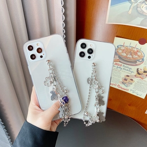 Detail of white translucent phone case with silver chain and metal bear charms