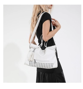 Detailansicht der weißen Shopper-Tasche mit silbernen Nieten und Leder-Quasten