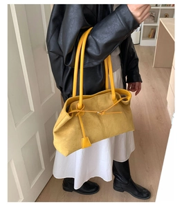 Close-up of yellow faux suede tote bag detailing soft texture and decorative thin strap