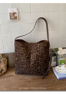 Detailansicht der Shopper-Tasche mit Leopardenmuster auf rustikalem Holztisch im Café-Stil