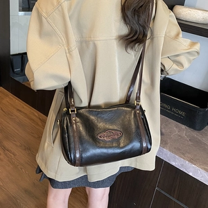 Retro Boston shoulder bag in black lychee leather worn by model in streetwear style