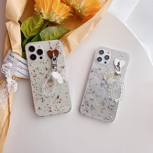 Detail of iPhone clear case with gold foil fragments and butterfly wrist strap charm