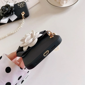 Macro detail of phone case showing precise charging port cutouts and pearl handle chain