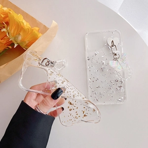 Detail of clear flexible TPU case with gold foil inlays and iridescent butterfly chain charm