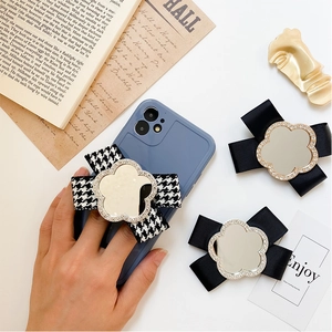 Detail of a floral mirror phone grip with a chic black and white houndstooth fabric bow