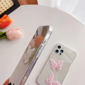 Detail of iPhone case featuring delicate lace butterfly embroidery on clear acrylic back