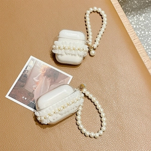 Detail of transparent lace AirPods case featuring white pearls and elegant pearl strap