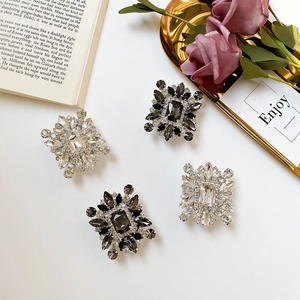 Detail of vintage square rhinestone brooches with shimmering crystals on an elegant background