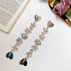 Detail of silver-tone tassel heart charms with iridescent leaf crystals for DIY crafts