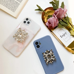 Close-up of luxury marble and matte blue phone grips with large geometric rhinestones