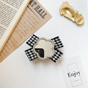 Detail of houndstooth bow phone socket with clover mirror and crystal accents