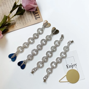 Detail of silver rhinestone chains with heart charms and snap hooks for DIY accessories