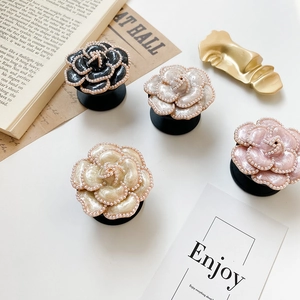 Macro shot of camellia flower phone grips with pearl edges in four elegant colors
