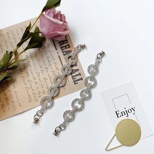 Close-up of interlocking rhinestone-studded circular links with polished metal clasps