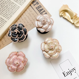 Detailed view of camellia flower phone grips in black, white, pink and champagne