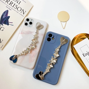 Detalle de cadena de diamantes de corazón en fundas de móvil mármol y azul